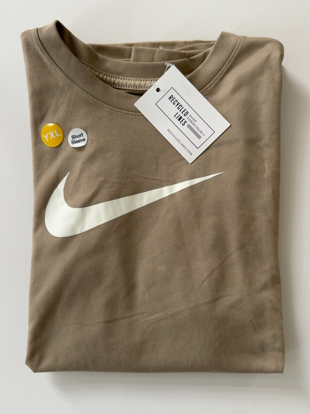 Original photo of tan Nike short sleeve boys XL T-shirt with large white swoosh on white background