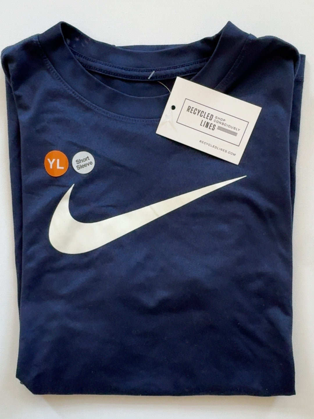 Nike navy short sleeve tee with white swoosh, boys size L, folded front view